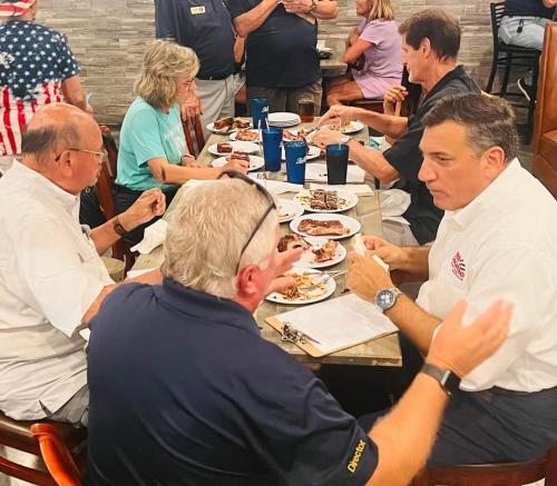 Judges Rick LoCastro, Steve Stefanides, Allyson Richards, and City Manager Mike McNees tasting the ribs for the cook off.  President Michael Hook is at table