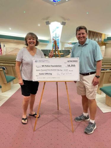 Pastor Reverend Dr. Mark Williams and Mrs. Michelle Hennessy Chair of the Missions Committee with a Prototype of the updated check that was donated to the Marco Island Police Foundation. Photo by Maria Lamb